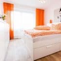 Ein orange-weiß eingerichtet Schlafzimmer.