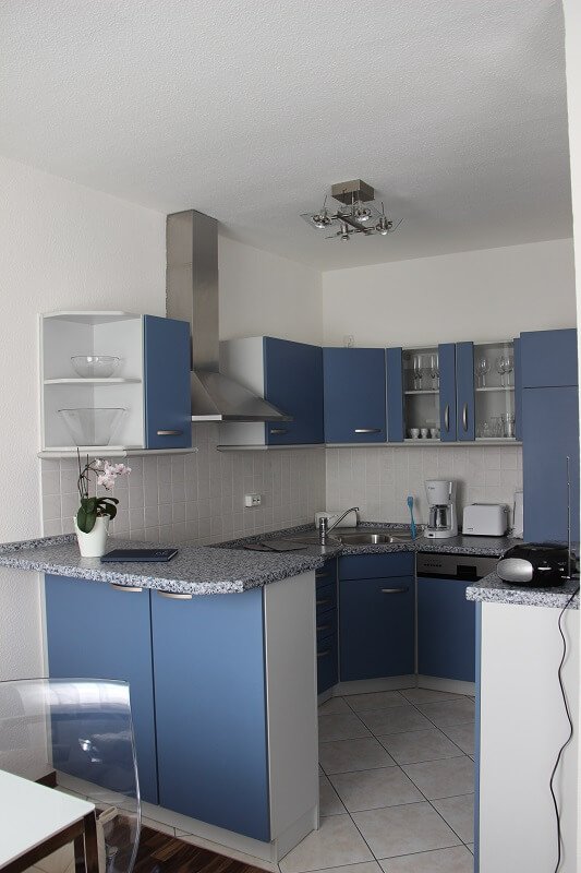 Eine blau eingerichtete Küche.