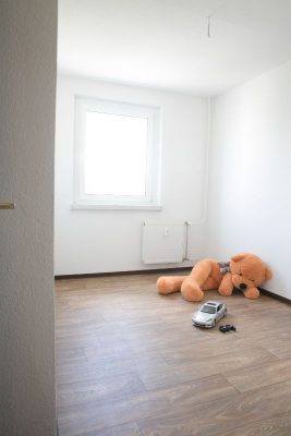 Ein leeres Kinderzimmer mit Spielsachen auf dem Boden.